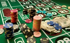 Ponsel menampilkan aplikasi betwinner dengan permainan Fish Hunter dimainkan dengan satu tangan